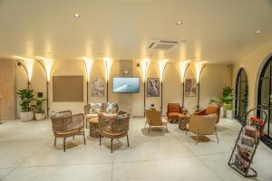 a lobby with chairs and tables in a building at Aura Inn & Suites in Mysore