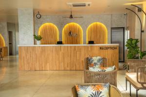 a hotel lobby with a reception desk and chairs at Aura Inn & Suites in Mysore +89 photos