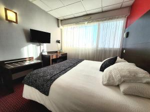 a hotel room with a bed and a television at Atlantic Hôtel in Pau