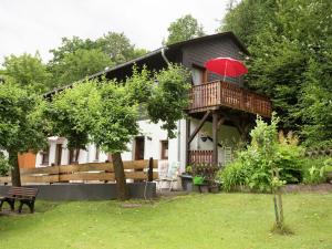 a house with a balcony with a red umbrella at Ferienwohnung Oberschledorner Wald in Medebach