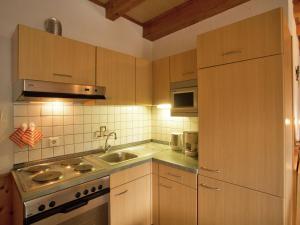 a kitchen with wooden cabinets and a sink at Ferienwohnung Oberschledorner Wald in Medebach
