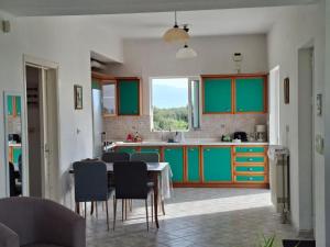 a kitchen with green cabinets and a table and chairs at APARTMENT Sonia in Análipsis