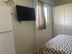 a bedroom with a bed and a flat screen tv on the wall at MH Oasi in Stazione di Albinia
