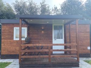 a tiny house with a porch and a shed at MH Oasi in Stazione di Albinia