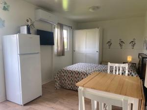 a small kitchen with a white refrigerator and a table at MH Oasi in Stazione di Albinia +11 photos