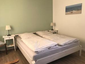 a bedroom with two beds and two tables with lamps at Ferienhof Martens in Sörup
