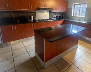 a kitchen with wooden cabinets and a large island at 44SeagullMelkbosstrand in Melkbosstrand