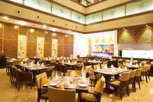 a restaurant with tables and chairs in a room at Royal Orchid Central Kireeti Hampi in Hampi