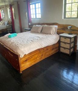 a large bed with a wooden frame in a bedroom at 44SeagullMelkbosstrand in Melkbosstrand