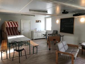 a living room with a table and a chalkboard at Ferienhof Martens in Sörup