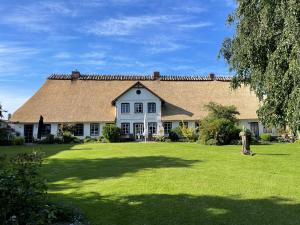 a large white house with a large yard at Ferienhof Martens in Sörup