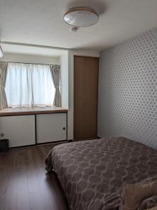 a bedroom with a bed and a window at T&T Fujiyama MC2 in Iiyama