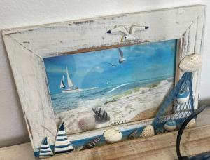 a picture of a painting of a beach with a sailboat at 44SeagullMelkbosstrand in Melkbosstrand