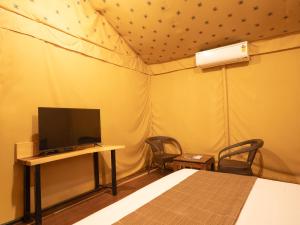 a bedroom with a bed and a tv in a tent at Hotel Marigold Mount Abu - With Swimming Pool in Mount Ābu