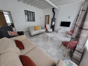 a living room with a couch and a tv at La marine D'opale in Ambleteuse