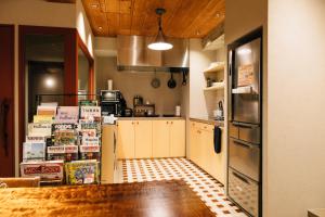 a kitchen with a refrigerator and a counter with books at Nui. HOSTEL & BAR LOUNGE in Tokyo +50 photos