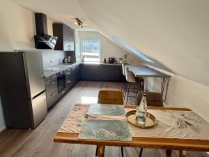 a kitchen and dining room with a table and a kitchen with a staircase at Spessart Escape - Ihr stilvoller Rückzugsort im Herzen des Spessarts in Mespelbrunn
