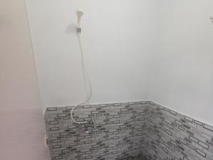 a shower in a bathroom with a brick wall at corak alam glamping in Tangkubanperahu