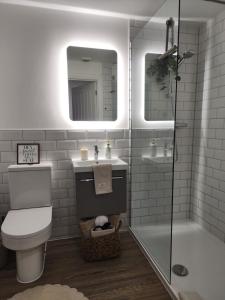 a bathroom with a toilet and a sink and a shower at Seashell Retreat in Bournemouth +23 photos
