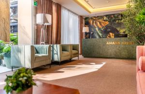 a lobby with couches and plants in a building at Amana Hotel Airport in Ho Chi Minh City