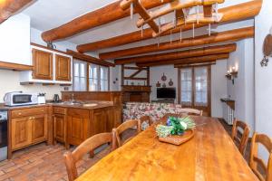 a kitchen and dining room with a wooden table at Tabia Maredane in Falcade
