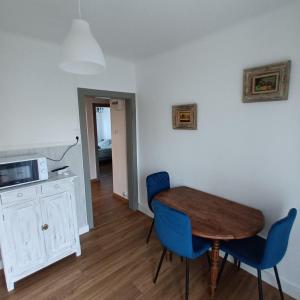 a dining room with a table and blue chairs at charming apartment in Stiring-Wendel