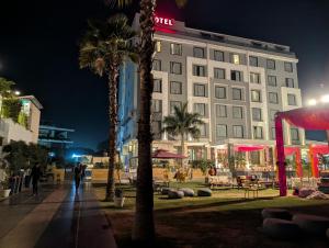 a hotel with palm trees in front of a building at Love Kush Hotel in Kishangarh