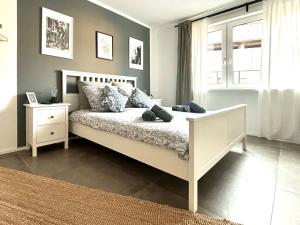a bedroom with a white bed and a window at COZEE - Central Apartment with Netflix in Kaiserslautern