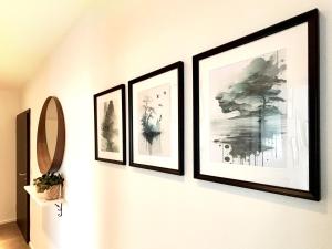 a group of four framed pictures on a wall at COZEE - Central Apartment with Netflix in Kaiserslautern +29 photos