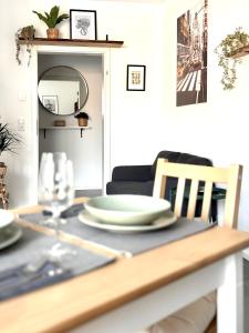a dining room table with plates and a glass at COZEE - Central Apartment with Netflix in Kaiserslautern