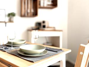 a wooden table with two bowls on top of it at COZEE - Central Apartment with Netflix in Kaiserslautern