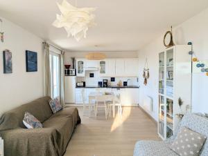 a living room with a couch and a kitchen at 11- Clapotis de l'Ô - Balcon sur la Mer - Parking Privé in Ault
