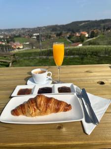a plate of food with a croissant and a glass of orange juice at El Mirador de Deva in Deva +60 photos