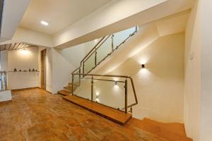 an empty room with a staircase in a house at Gauri Villa by ELIVAAS With Pool, Lounge, Garden & Bathtub With 360 Panoramic Hill Views Near Waterfalls in Kasāra +53 photos