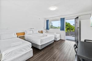 a hotel room with two beds and a balcony at Annerley Motor Inn in Brisbane