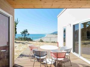 a patio with chairs and a table with a view of the ocean at VILLA YAHACHI GARDEN in Tahara +14 photos