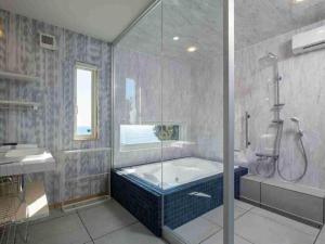 a bathroom with a tub and a shower and a sink at VILLA YAHACHI GARDEN in Tahara