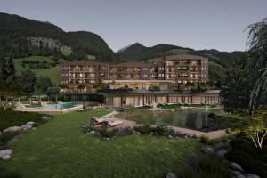 a rendering of a hotel with a pond and mountains at Naturhotel MOLIN in San Giovanni in Val Aurina