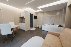 a living room with a couch and a table and a tub at Artemide Suite Spa in Lido Di Fondi