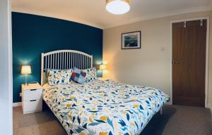 a bedroom with a bed and a blue wall at Maesyfelin Isaf Apartment in Llanybyther