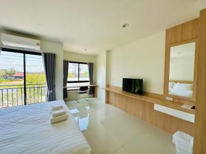 a bedroom with a large bed and a television at SK Residence & resort in Ban Nong Pla Mo