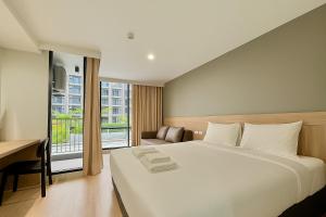 ein Schlafzimmer mit Bett, Schreibtisch und Fenster in der Unterkunft Rangsit Residence & Hotel by HOTEL DD in Ban Talat Rangsit + 13 Fotos
