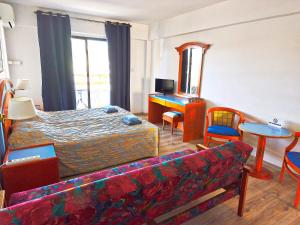a hotel room with a bed and a couch at Petalmo City Apartments in Larnaca