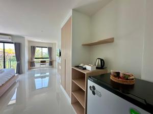 a room with a bed and a kitchen with a counter at SK Residence & resort in Ban Nong Pla Mo