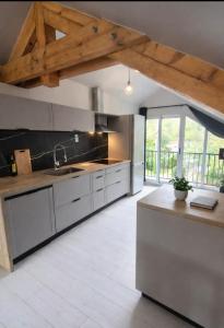 a kitchen with white appliances and a wooden ceiling at Frida's house in Bièvres +13 photos