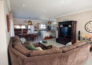 a living room with a large couch and a kitchen at AllesWells in Yzerfontein