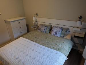 a small bedroom with a bed and a dresser at Rasteplassen in Stordalen
