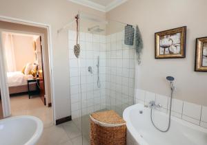 a bathroom with a tub and a shower and a sink at AllesWells in Yzerfontein +12 photos