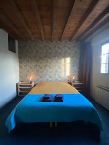 a bedroom with a bed with two slippers on it at Gîte Asaliah in Sainte-Colome