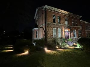 a large brick house at night with lights in the yard at Cornerstone Manor Hotel in Sale +46 photos